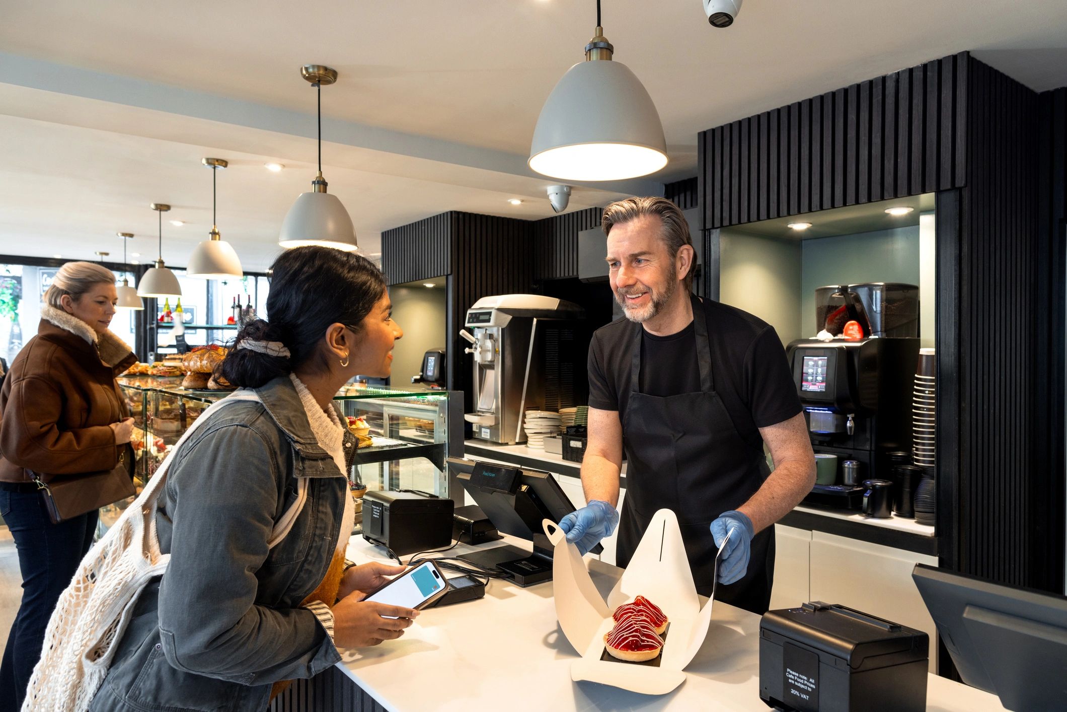 Smiling grocery staff member assisting a customer